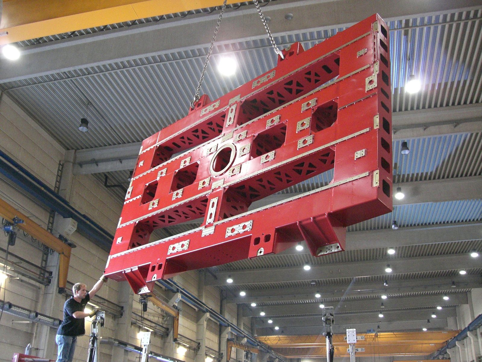 Red-painted machine bed after mechanical CNC milling being transported by heavy-load crane at Bock Maschinenbau GmbH Lorch