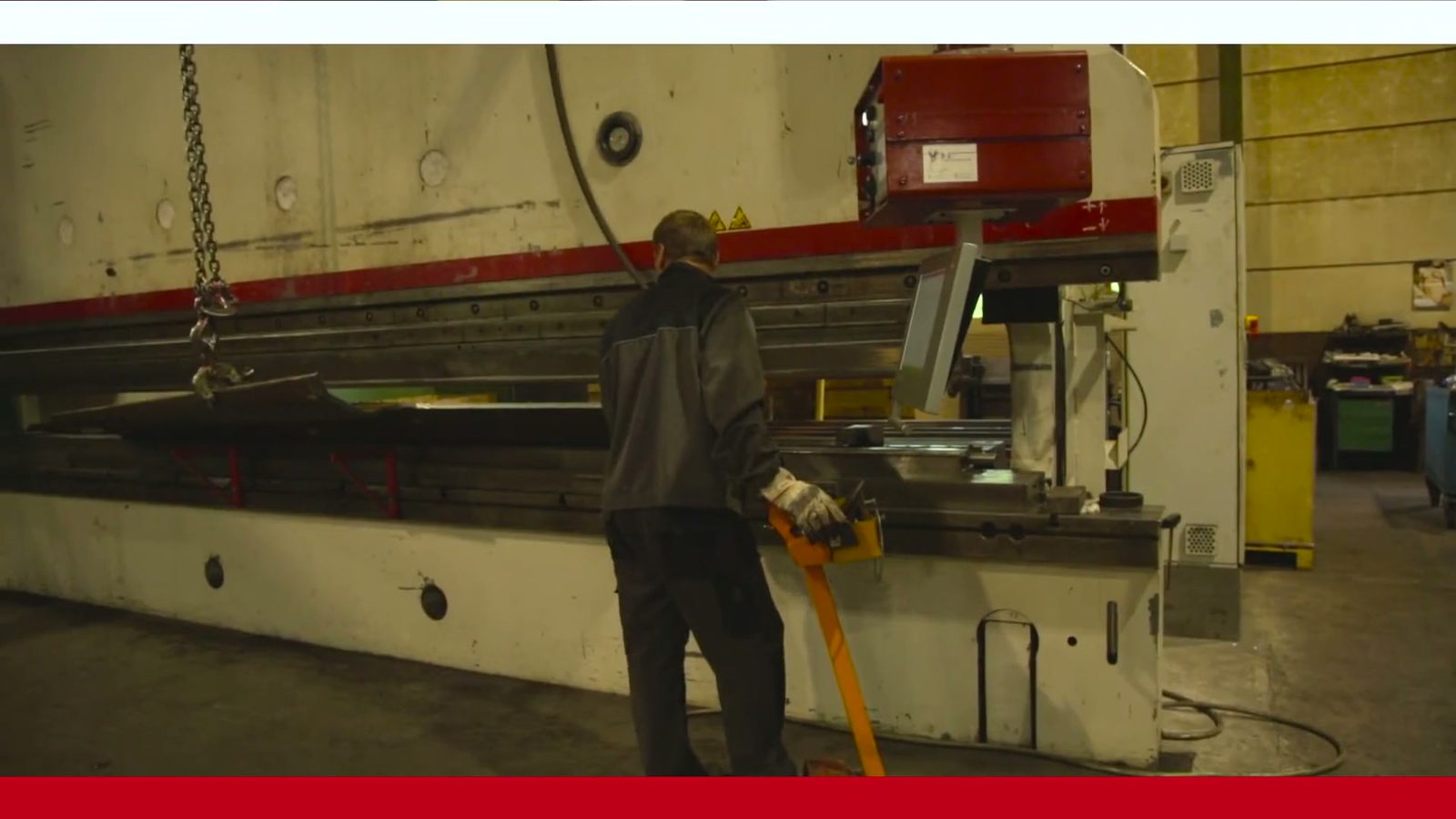 Operator la presa de îndoit hidraulică în timpul îndoirii tablelor mari de oțel în hala de producție a Bock Maschinenbau GmbH din Lorch