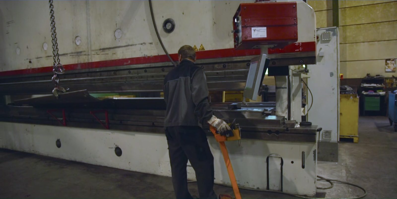 Operátor pri hydraulickom ohraňovacom lise počas ohraňovania veľkých oceľových plechov vo výrobnej hale Bock Maschinenbau GmbH v Lorchu